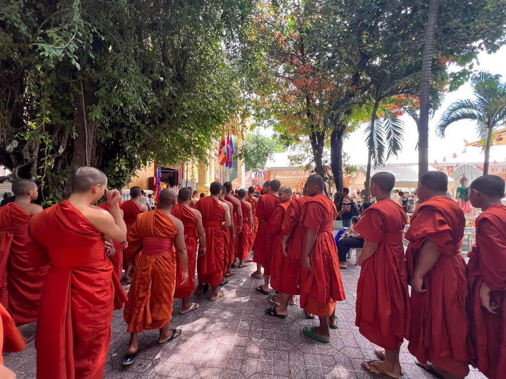 Siem Reap Private Tour - Buddhist monks in saffron robes walking in line to have lunch – a daily ritual that reflects discipline, mindfulness, and the monastic way of life in Cambodia.