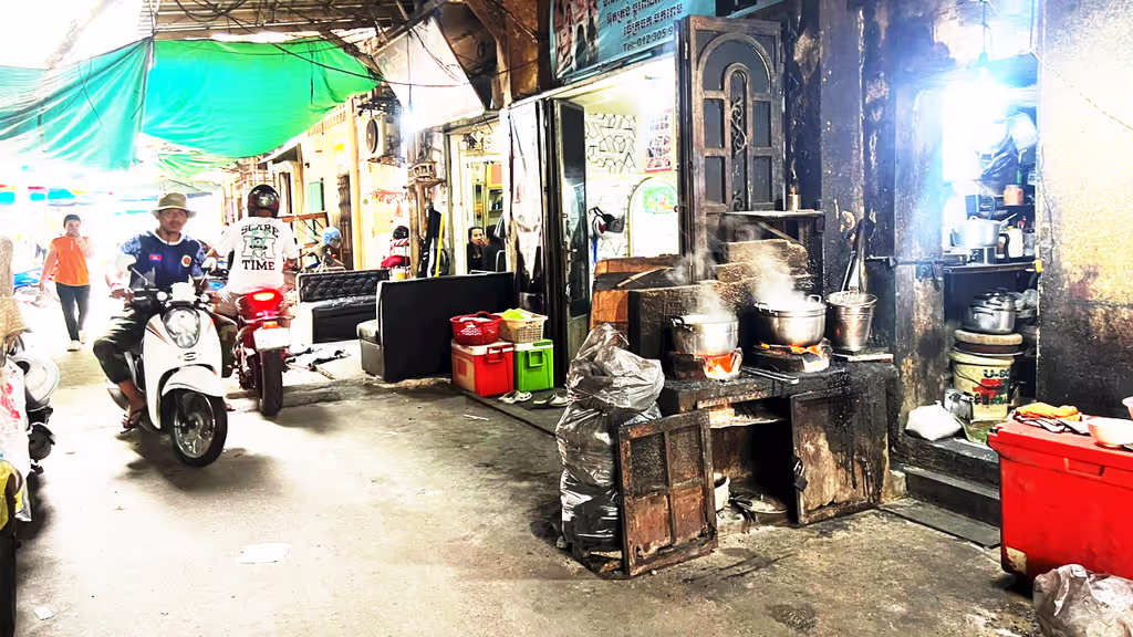 Siem Reap Private Tour - Everyday alleyway life in Phnom Penh – motorbikes passing by as steaming pots of rice cook on open stoves, blending the rhythm of traffic with the aroma of street food.