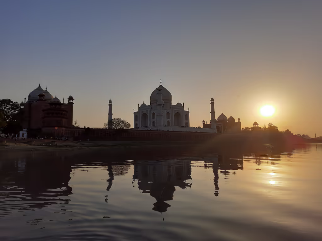 Delhi Private Tour - The sunset view of the Taj Mahal is a mesmerizing spectacle that bathes this iconic monument in a warm, golden light. As the sun dips below the horizon, the pristine white marble of the Taj Mahal takes on a serene and ethereal glow. 
