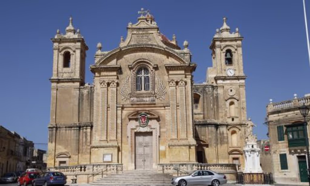 Malta Private Tour - The Qrendi Parish Church is dedicated to The Assumption. It is a Roman Catholic Church, it was built by a Maltese architect Lorenzo Gafa and it is in a form of a Latin Cross. In our village we celebrate two feasts, one on the 1st Sunday of July 'Our Lady of Lourdes' and the other one on the 15th of August 'The Assumption' (Our Lady risen in Heaven). 
