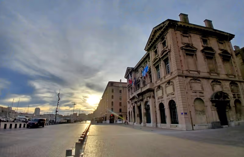 Marseille Private Tour - Looking past the Hotel de Ville (town hall) to the end of the Vieux Port, the two defensive bastions of Fort St. Jean and Fort St. Nicolas are visible.