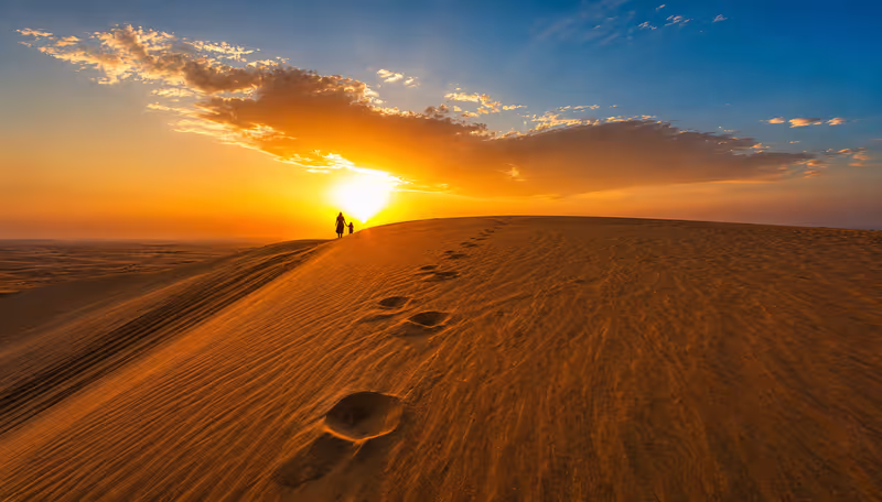 Doha Private Tour - Sunset over Qatar’s golden desert dunes.