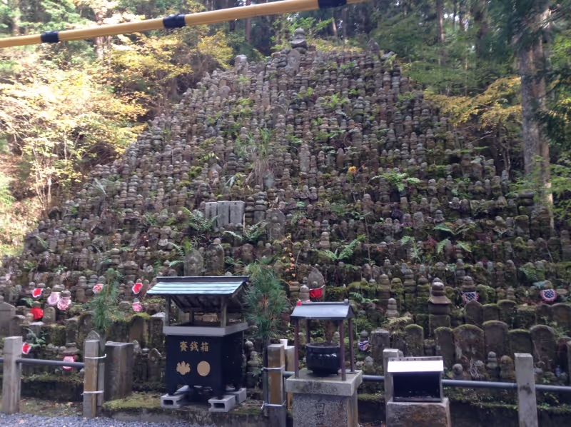 Osaka Private Tour - This picture shows a pyramid made of buddha statues of someone with no relatives to mourn their death. Commoners can not build thier tomb here. So a lot of people put a small a buddha statue beside the trail. And they are gathered here.